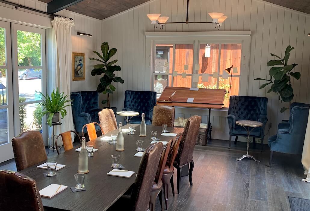 Elegant Napa corporate meeting space featuring velvet chairs and large windows in Yountville’s Handwritten Wines.