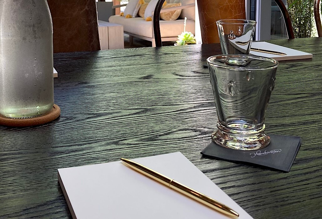 Close-up of a premium Napa corporate meeting setup featuring branded glassware and writing materials at Handwritten Wines.