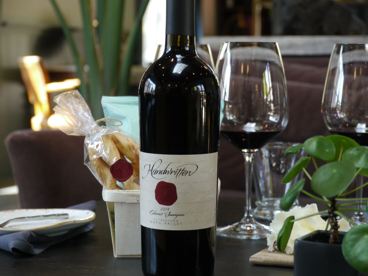 bottle of wine on table with wine glasses behind
