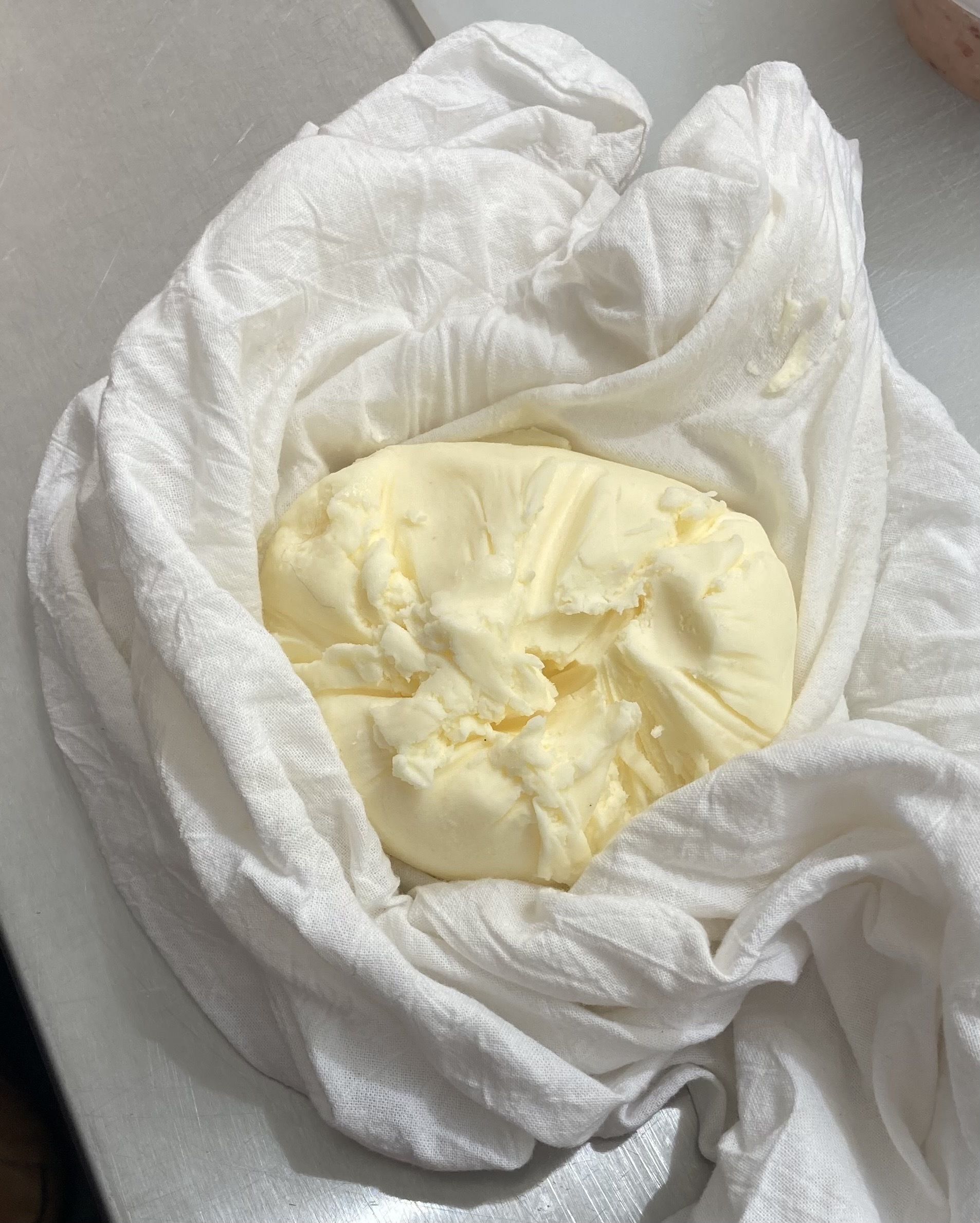 Soft pale yellow butter wrapped in a white cloth, a unique activity for Napa Winery private events.