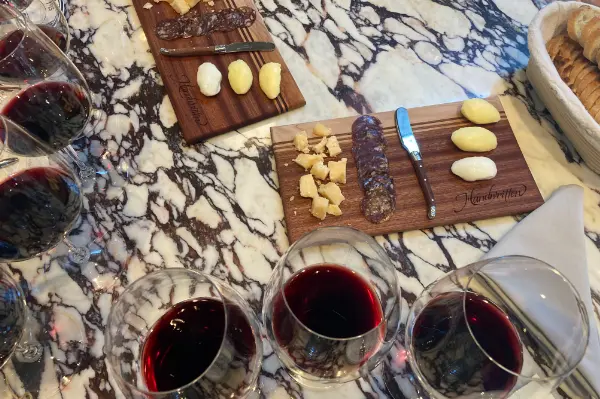 Overlook of Handwritten wines Bread & Butter tasting. You can see glasses of wine placed side-by-side and pairing platters in the center of the marble table.