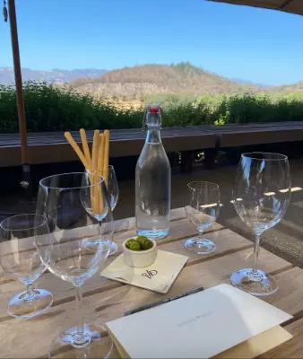 Glasses and menu on a patio table overlooking mountains of Napa Valley